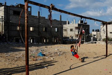 Ett barn gungar mitt under krisen i Gaza.