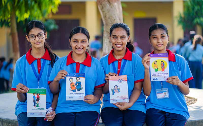 Fyra tonårstjejer i Nepal visar upp broschyrer om sexuell och reproduktiv hälsa och rättigheter (srhr). De är med i en ungdomsklubb på skolan där de lär sig om sina rättigheter och kroppar.