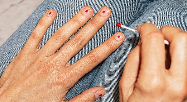 Någon målar fem röda prickar på naglarna för att uppmärksamma internaitonella mensdagen.